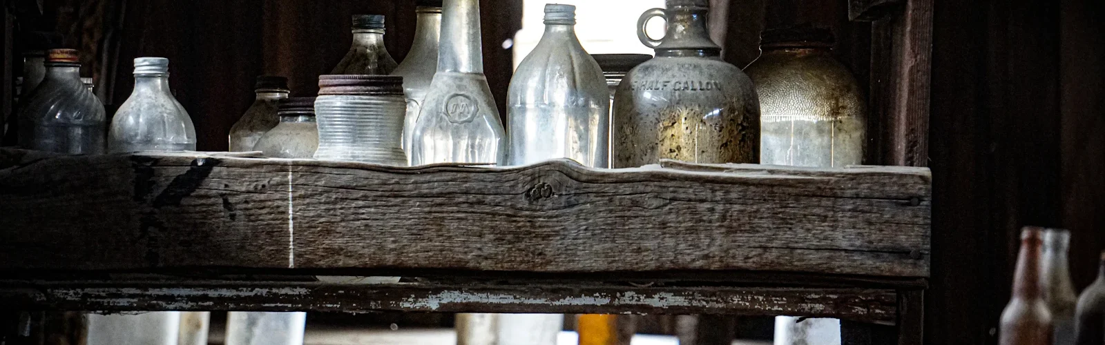 Stoffige flessen op een houten plank