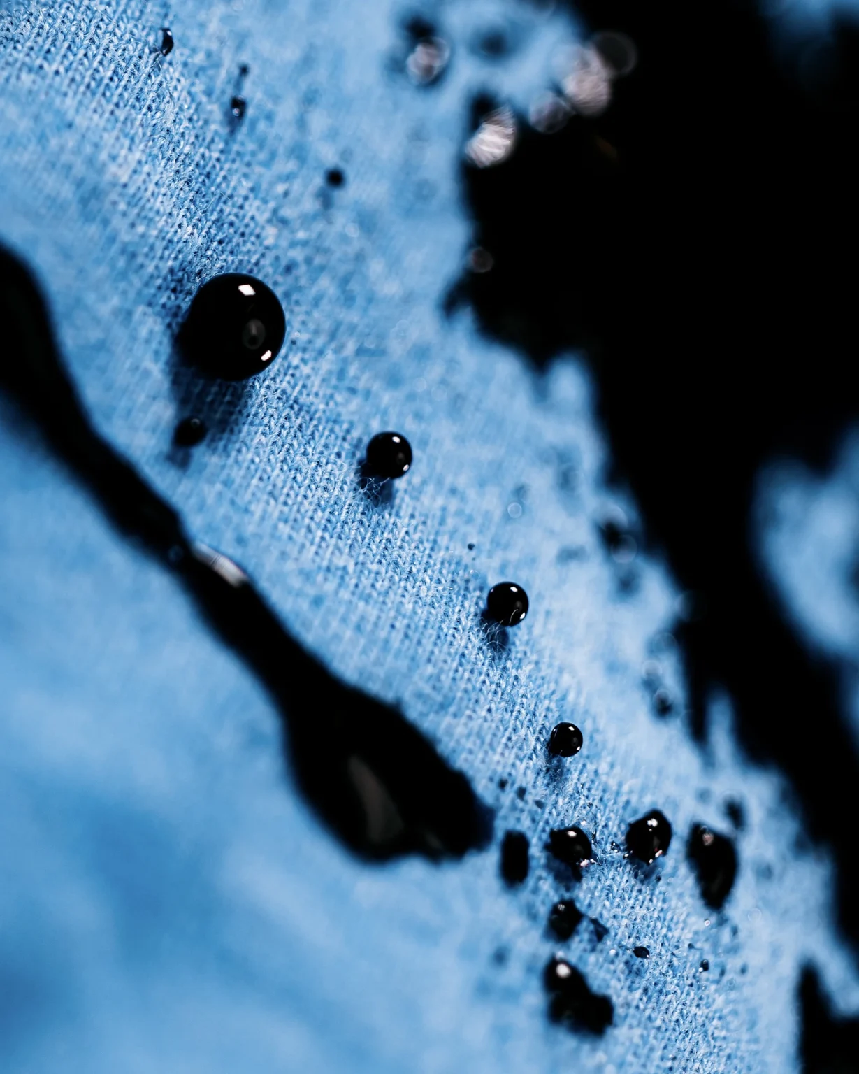 Waterdruppels op een blauwe stof van dichtbij