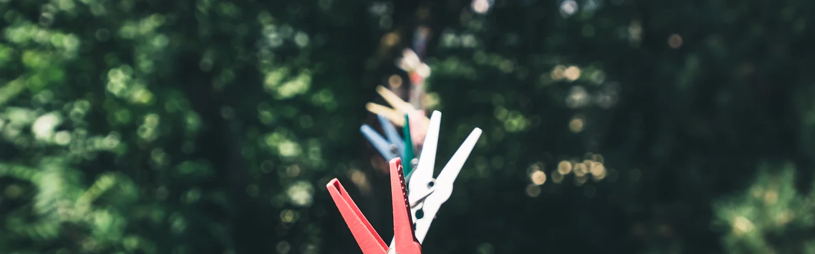 Wasknijpers aan een waslijn met groen op de achtergrond