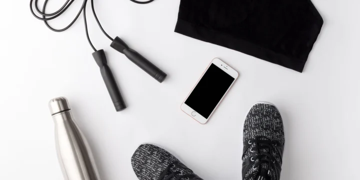 Sportkleding, schoenen en een bidon naast elkaar