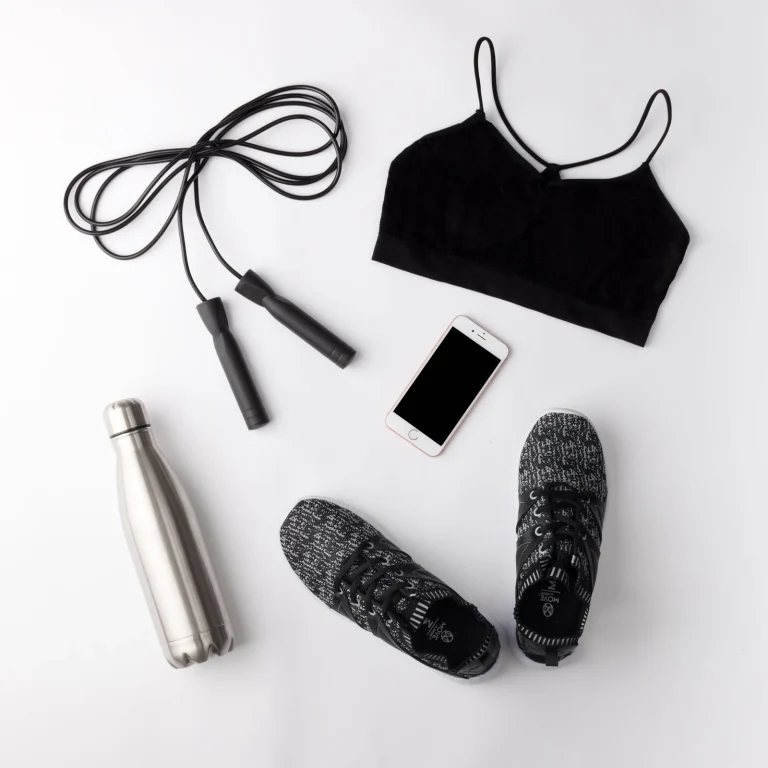 Sportkleding, schoenen en een bidon naast elkaar