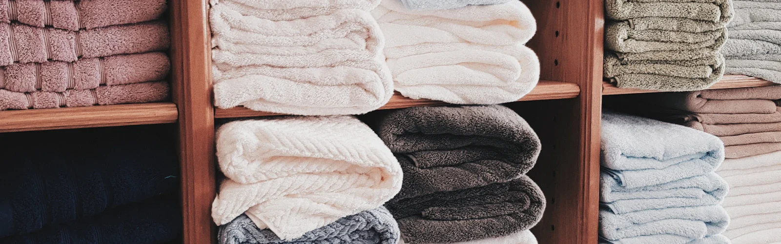 Opgevouwen textiel op een houten plank in de kast