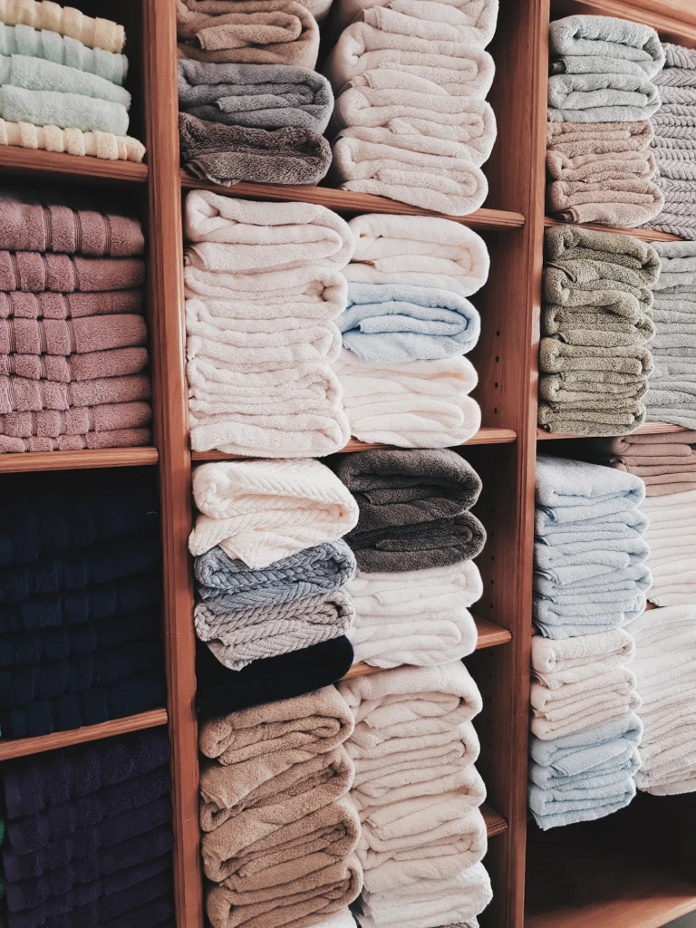 Opgevouwen textiel op een houten plank in de kast