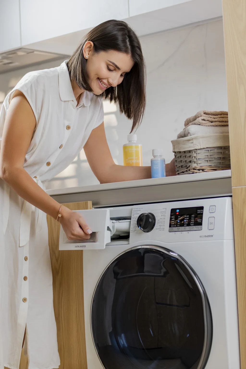 Iemand vult de lade van een wasmachine met vooropening