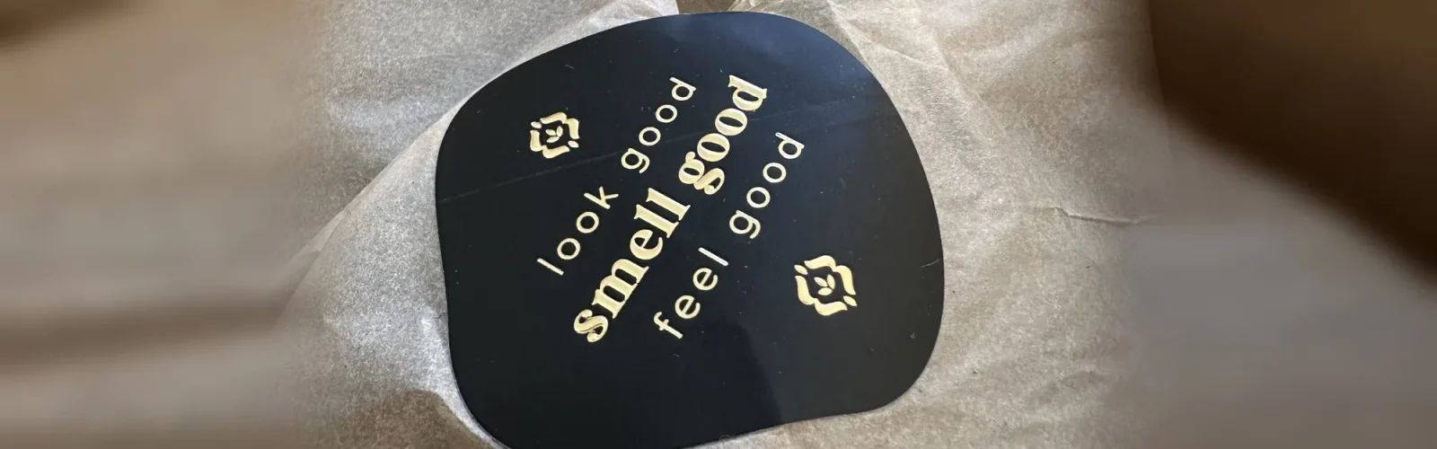 Pakket van Rosaodor in zijdepapier, met een zwarte sticker: look good, smell good, feel good